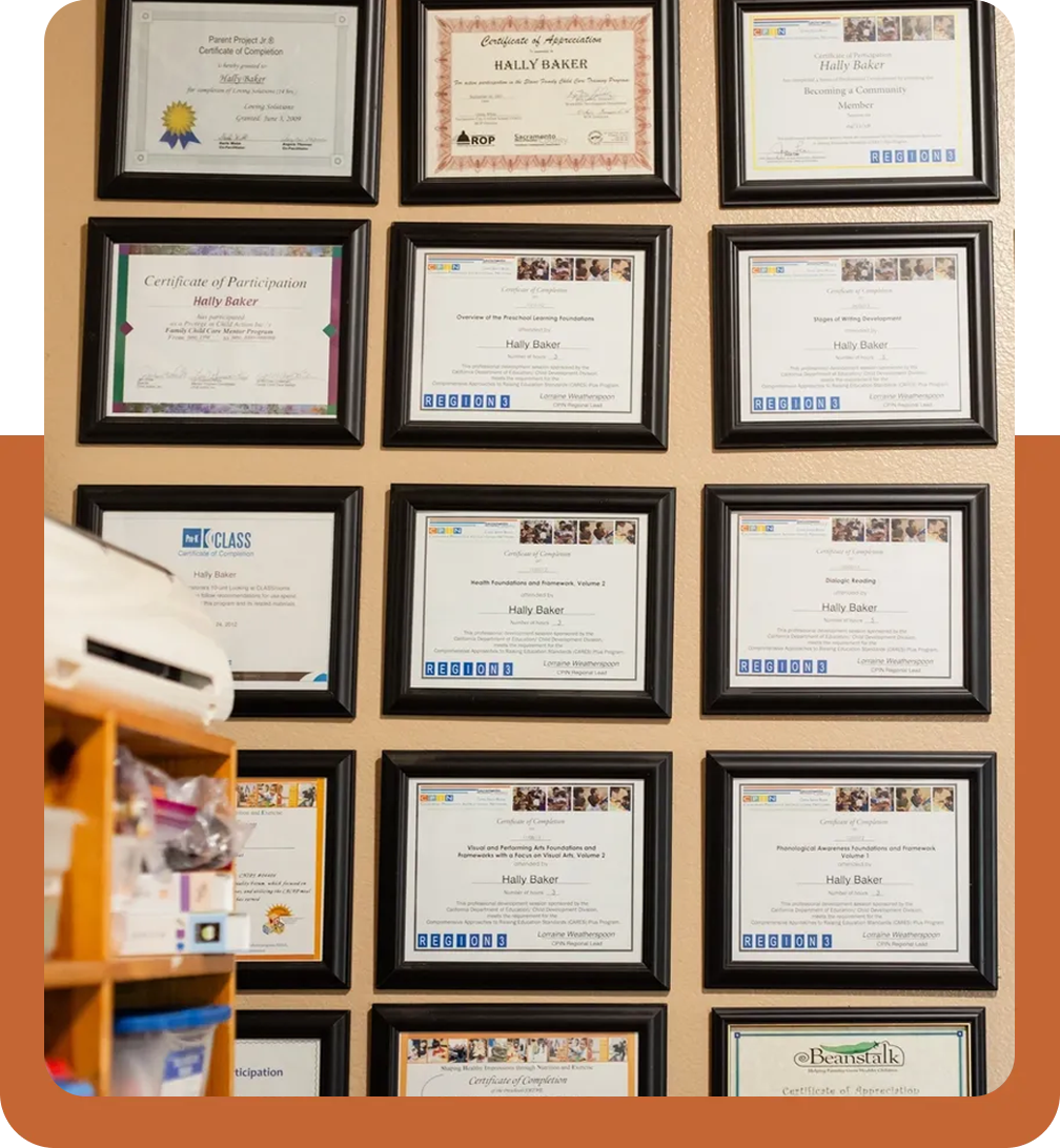 A wall of certificates hanging on the side of a room.