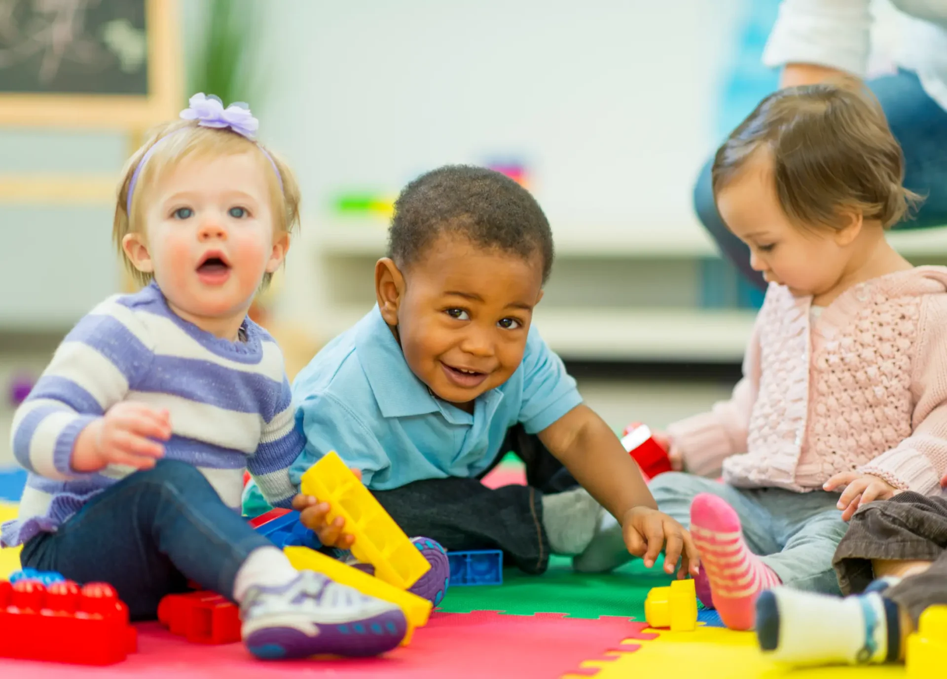 A group of children playing with blocks on the floor.