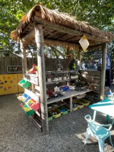 A wooden structure with a roof and shelves of food.