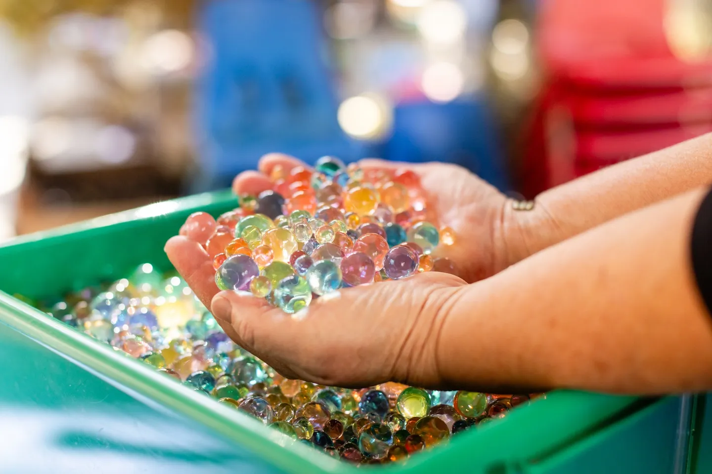 A person holding colorful beads in their hands.