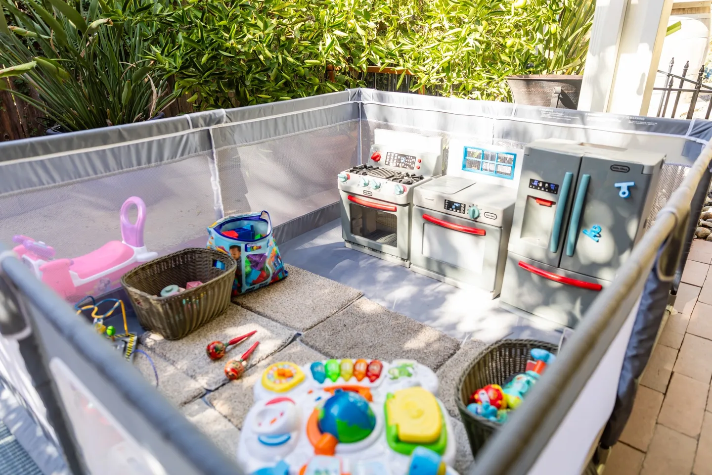 A play yard with toys and baskets on it.